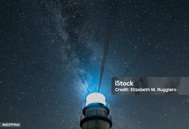Lighthouse At Night With Radiating Beams And Starry Sky With Milky Way Stock Photo - Download Image Now