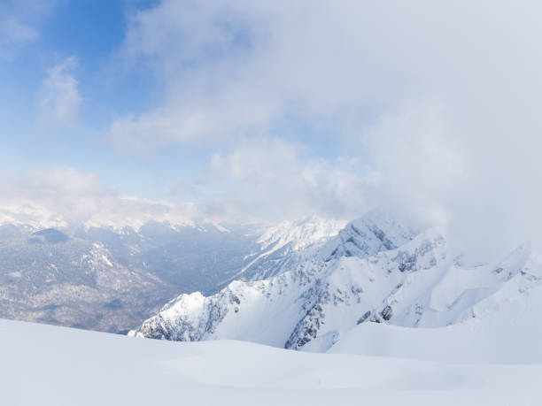 High mountains, lots of white snow and clouds lie on the mountains in Sochi, Russia