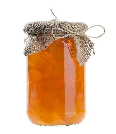 Orange jam in jar isolated on white.