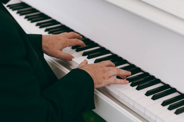 istock Man hands playing piano, close up 860299446