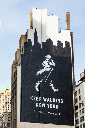New York: advertising for the whiskey Johnnie  Walker as mural at an old house facade.