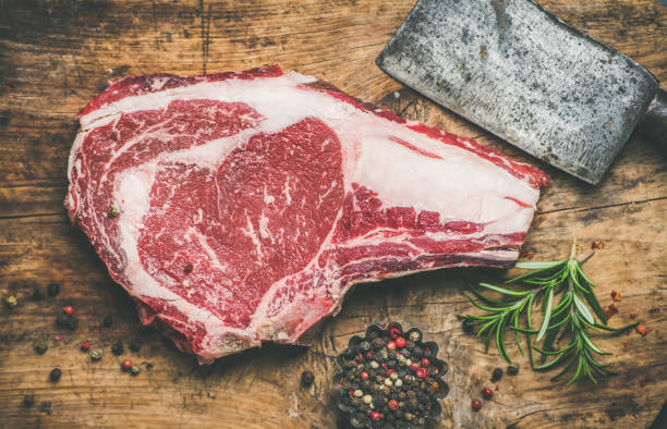生の牛肉ステーキ ロース調味料とナイフ、素朴な背景 - rib eye steak beef cutting board meat ストックフォトと画像