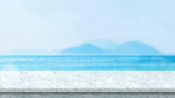 istock White marble table top with blurred bokeh sea and blue sky at background, Mock up template for display or montage of your product, Summer vacation concept,panorama view 860313586