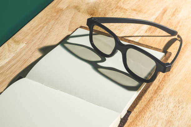 istock Close up black eyeglasses on open blank book with shadow light from window on wooden table top and blackboard wall,Education concept,study resting 860313592