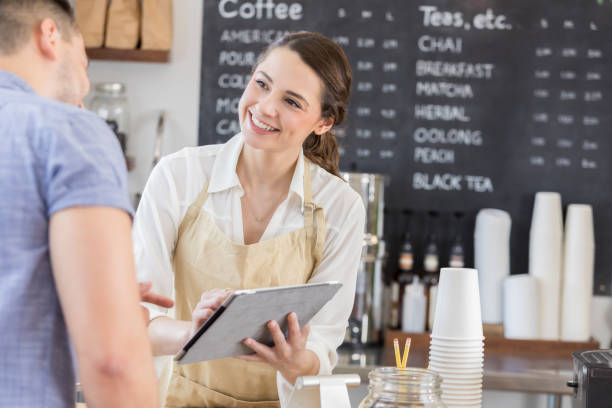 istock Female barista uses tablet to take customer order 860318388