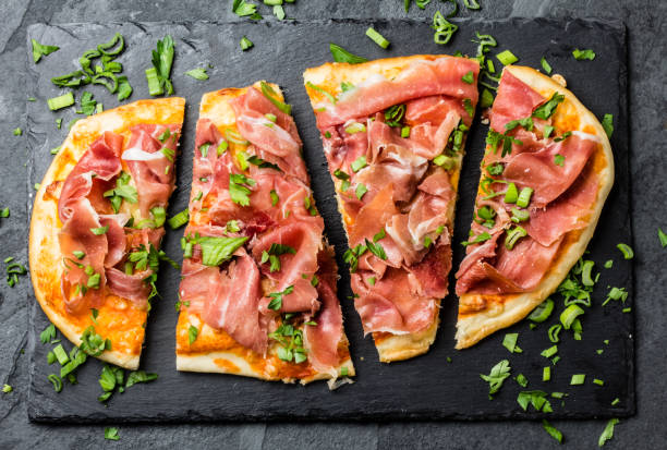 Homemade pizza with jamon serrano on slate plate Homemade pizza with jamon serrano, paleta iberica on slate plate. Stone background spanish fork utah stock pictures, royalty-free photos & images