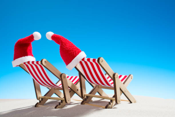 istock Christmas on the beach: two chairs and Santa's hats 860324682