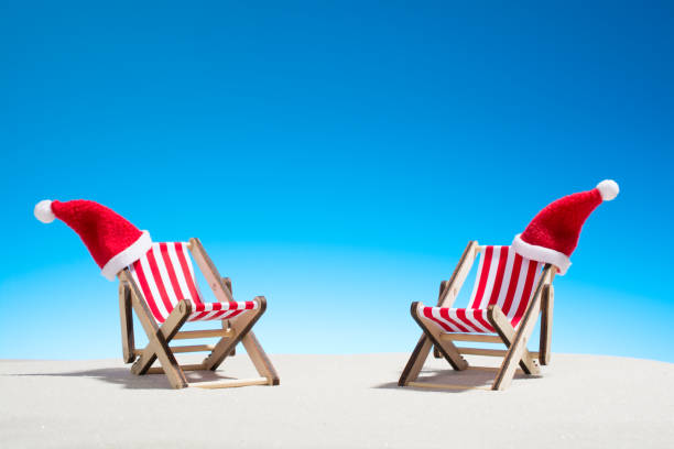 istock Christmas on the beach: two chairs and Santa's hats 860324698