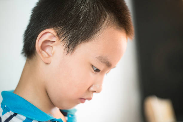 one asian boy playing ball and stick structure in the classroom
