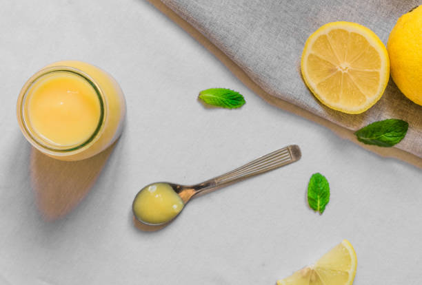 istock Lemon curd cream in a glass jar against white background 860359182