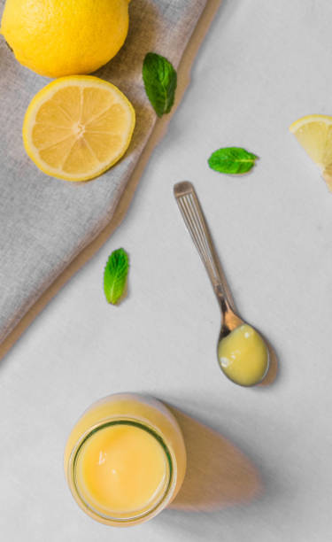 istock Lemon curd cream in a glass jar against white background 860359184