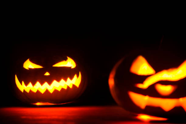 Halloween pumpkin glowing in the dark Creative Halloween Theme halloween pumpkin human face candlelight stock pictures, royalty-free photos & images