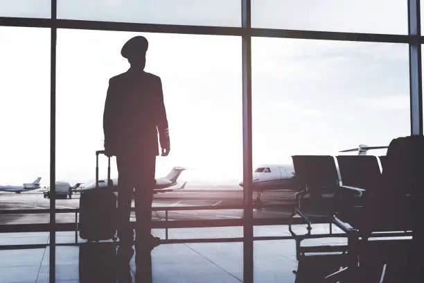 Photo of Aviator looking at big window in terminal