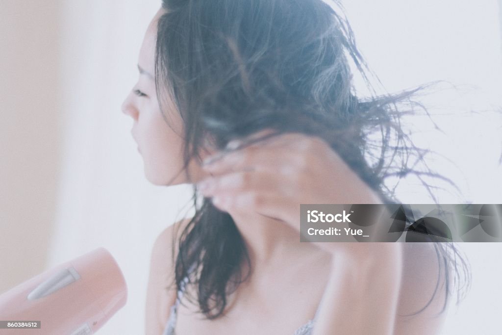 Mujer de secar su cabello con un secador de pelo en casa - Foto de stock de Mujeres libre de derechos