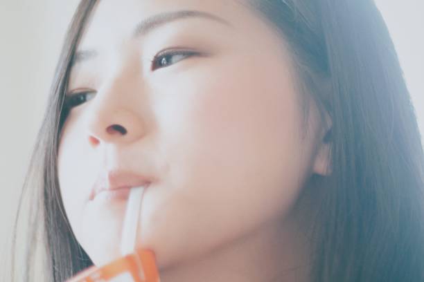 istock Woman drinking juice with a straw 860384582