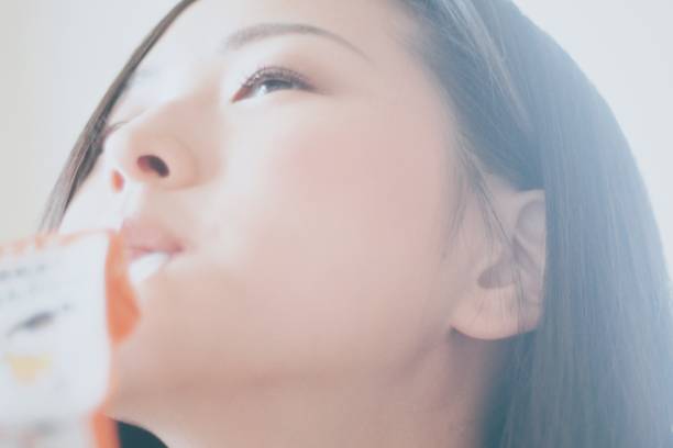 Woman drinking juice with a straw
