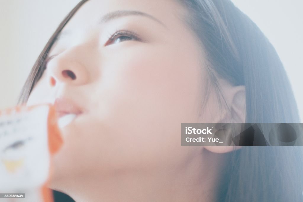 Woman drinking juice with a straw Woman drinking juice with a straw in Japan Women Stock Photo