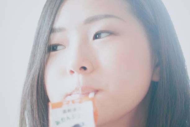 istock Woman drinking juice with a straw 860384636