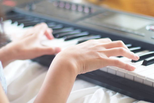 istock Woman's hand playing the electronic piano at home 860384660