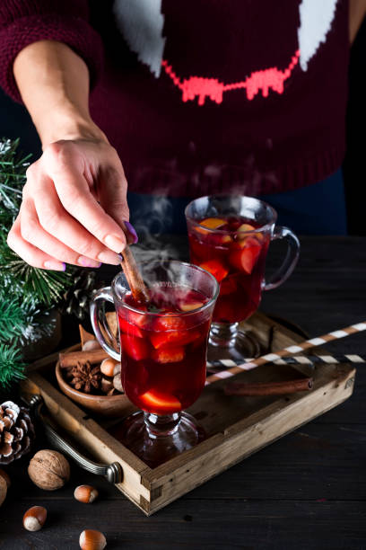 istock girl puts a cinnamon stick in hot mulled wine 860384698