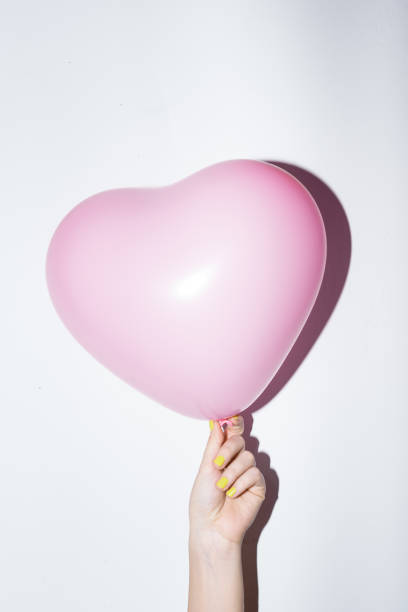 istock Pink heart baloon in hand 860388822