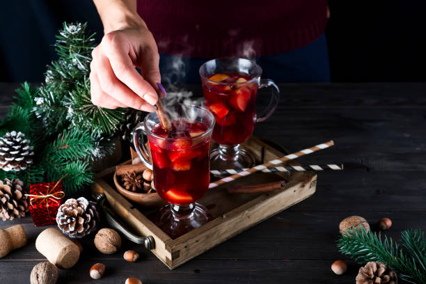 istock girl puts a cinnamon stick in hot mulled wine 860388934