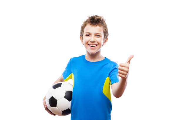 Handsome smiling child boy holding soccer ball gesturing thumb up success sign Handsome smiling child boy hand holding soccer ball gesturing thumb up success sign white isolated inflatable soccer balls stock pictures, royalty-free photos & images