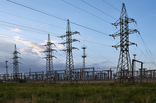 High voltage towers with sky background.