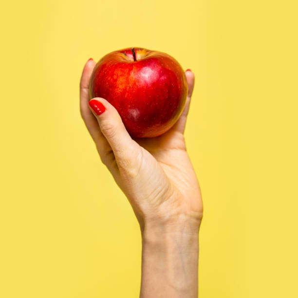 uma maçã em uma mão - women eating fruit food - fotografias e filmes do acervo