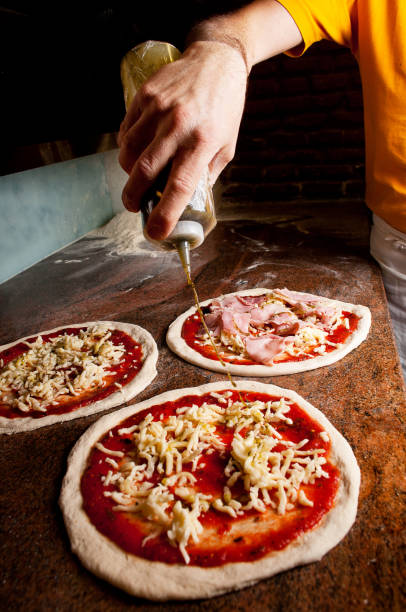 istock Adding extra virgin olive oil To Pizza 860407602