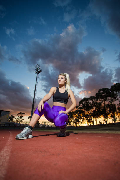istock Female sprinter athlete getting ready to start a race on a tartan racetrack 860410850