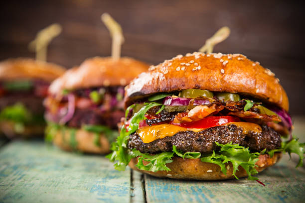 istock Tasty burgers on wooden table 860410962