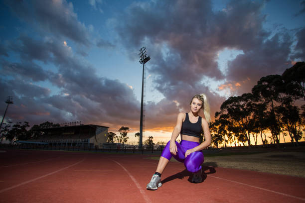 istock Female sprinter athlete getting ready to start a race on a tartan racetrack 860411492