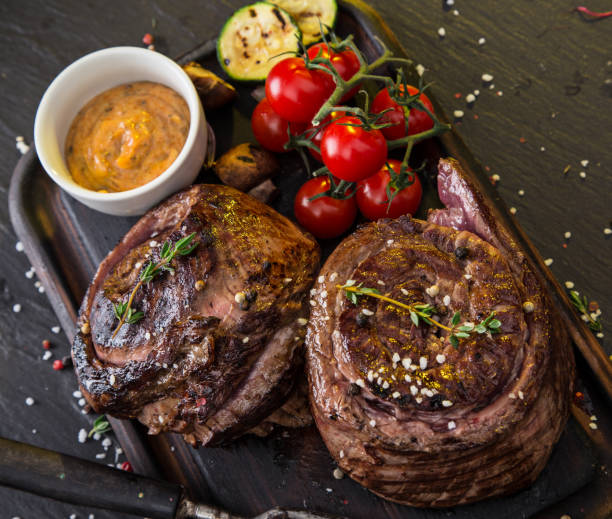 steak de boeuf délicieux sur la table en pierre noire - round of beef photos et images de collection
