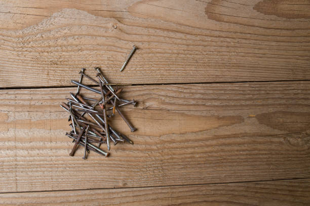 istock Screws and nails on a wooden surface ready to be used for a DIY project 860434746