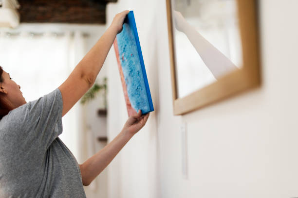 istock Woman hanging a picture frame on the wall 860436816