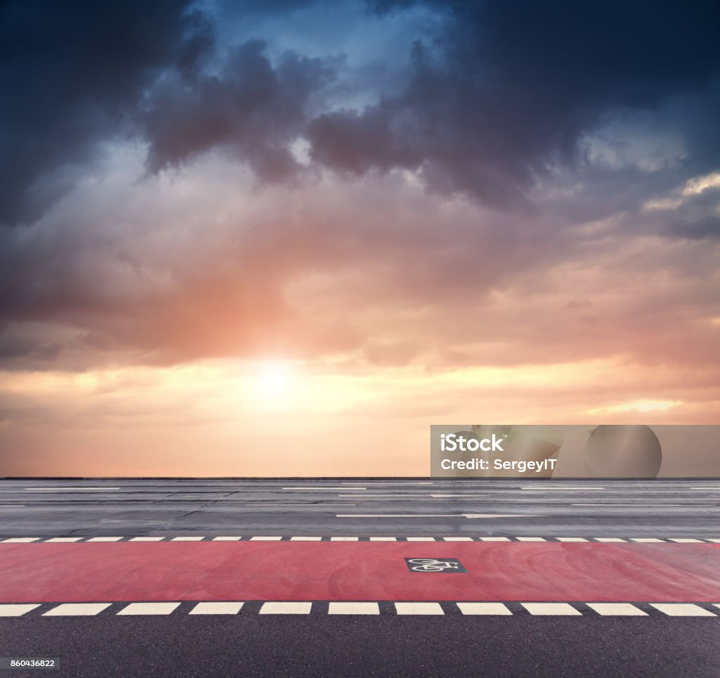 bicycle lane and dramatic sunset sky asphalt road on foreground Sunset Stock Photo