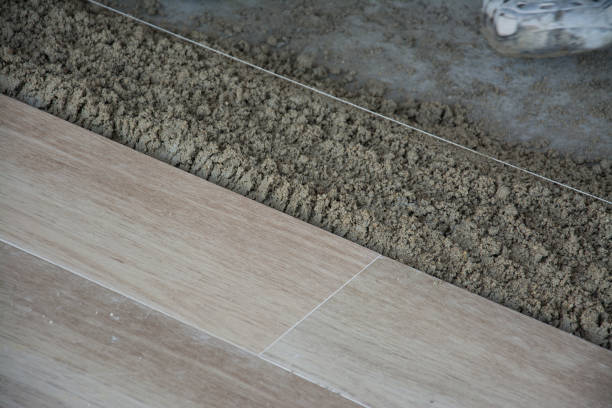 istock laying ceramic wood tiles on wall, installing tiles  in construction site. 860439410