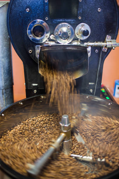 istock Freshly roasted coffee beans being poured into a cooling down rotater. 860440116