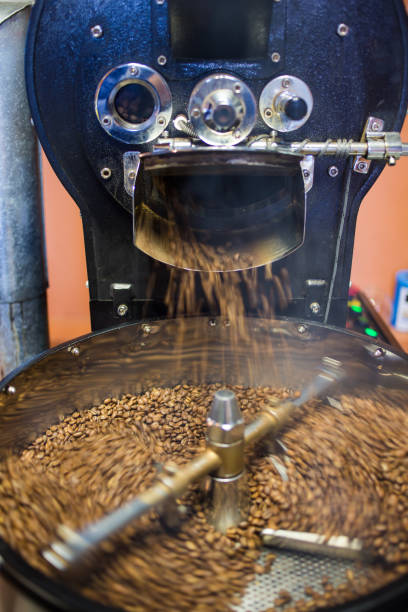 istock Freshly roasted coffee beans being poured into a cooling down rotater. 860440118