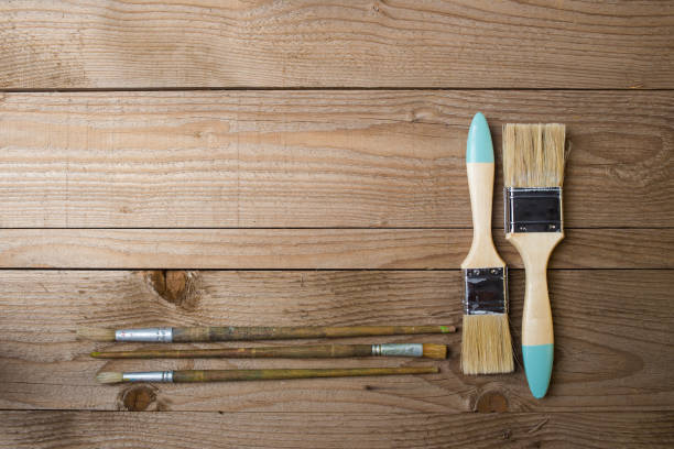istock Paint brushes on a wooden surface ready to be used for a DIY project 860443404
