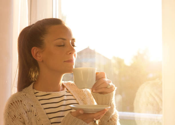 istock Girl with cup of coffee beside window 860450508