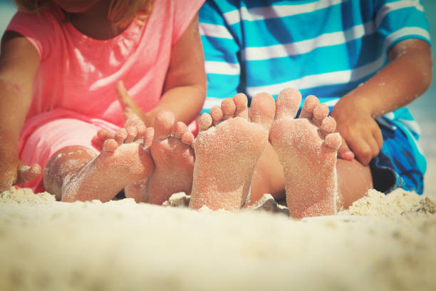 istock kids feet on sand beach, vacation concept 860454844