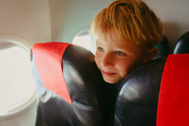 istock kids travel- cute little boy in plane 860455382