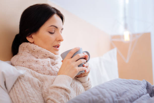 istock Tired ill woman looking at her cup 860455428