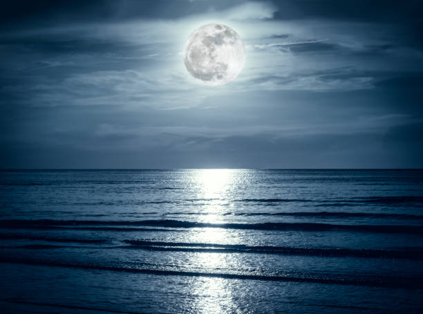 istock Colorful sky with dark cloud and bright full moon over seascape. 860456520