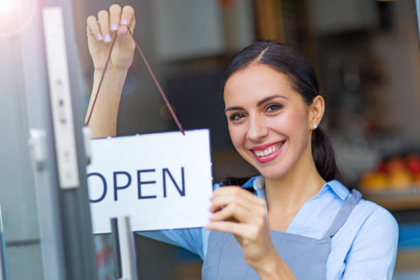 istock Woman holding open sign in cafe 860459464