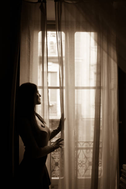 istock Woman looking outside window 860462578