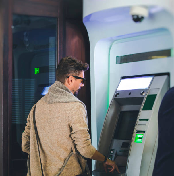 istock Young businessman withdrawing money from a cash machine 860471638