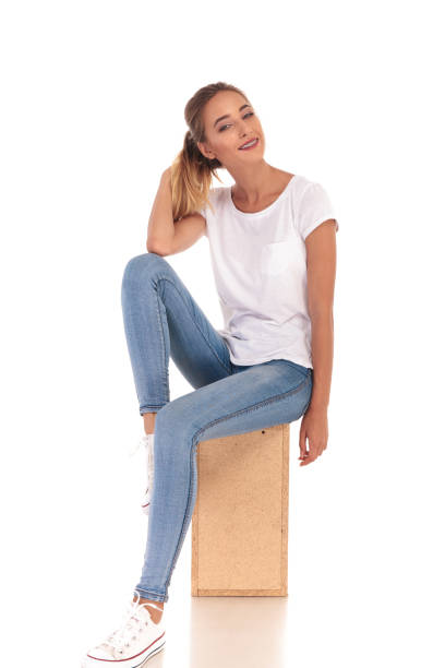 istock smiling  woman playing with her ponytail sitting on wooden box 860484862